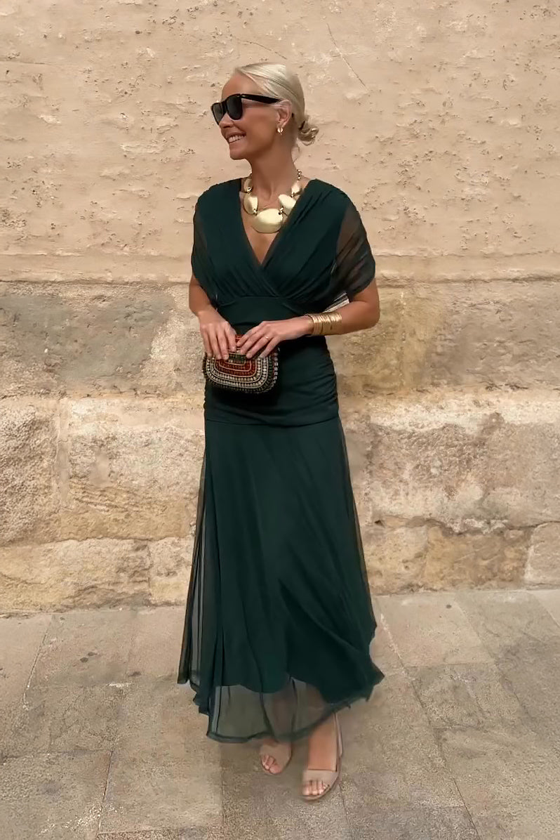 Woman in bottle green V-neck chiffon maxi dress with gold jewellery
