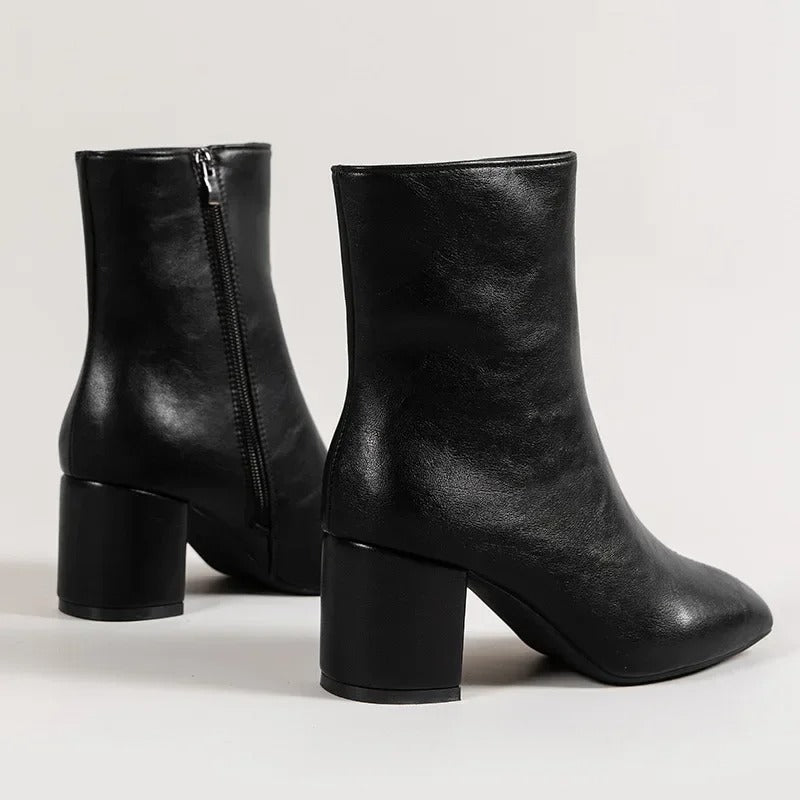Close view of the block heel and sole on pointed toe ankle boots