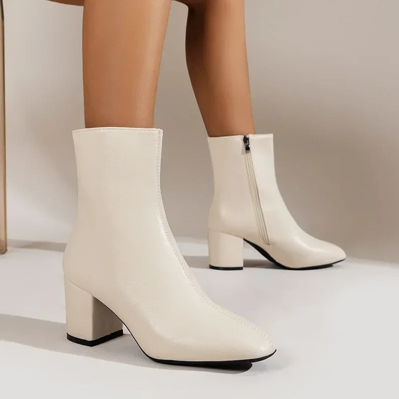 Women's beige ankle boots shown from the side with side zip