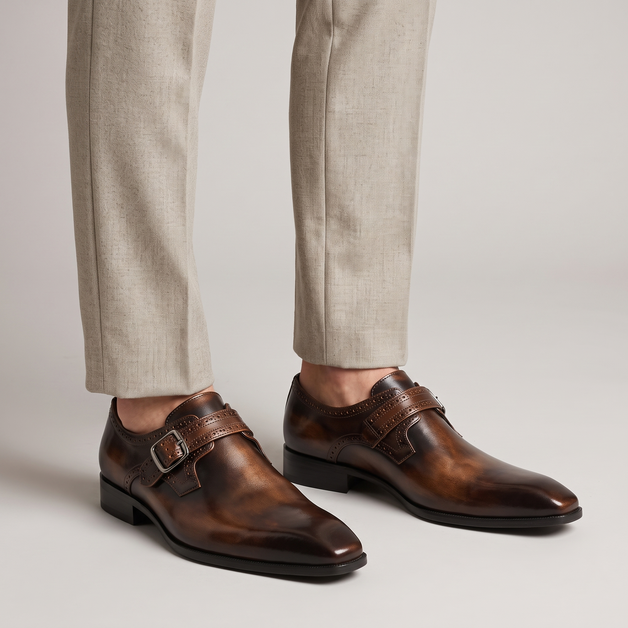 Men's brown burnished monk strap shoes with chisel toe worn with stone wool trousers