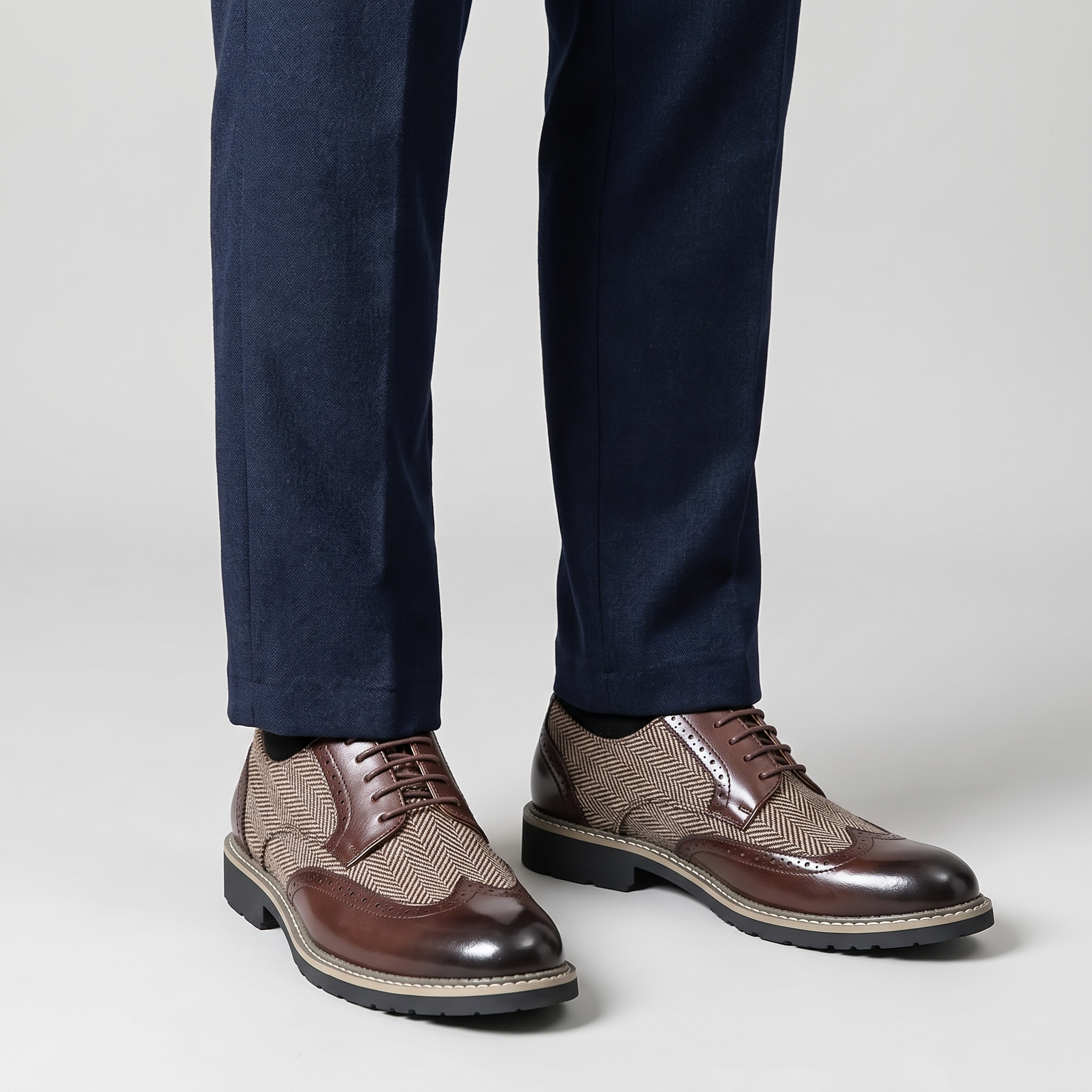 Men's brown herringbone tweed panel wingtip brogues worn with navy wool trousers