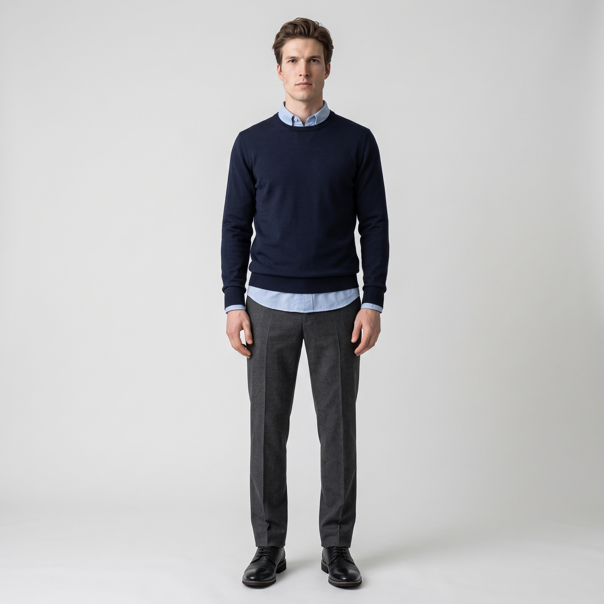 Man wearing black cap toe Derby shoes with charcoal trousers and a navy jumper