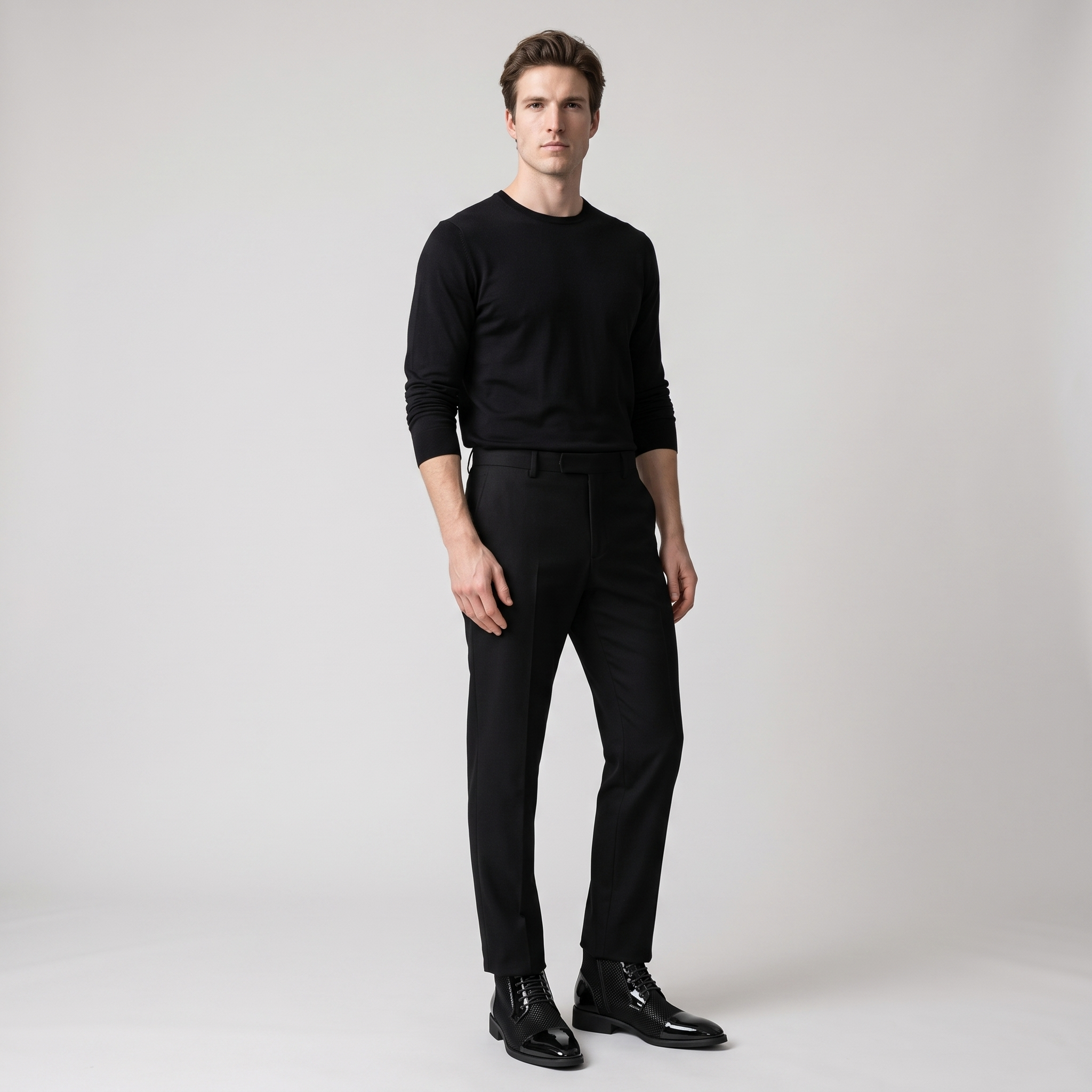 Man wearing black patent cap toe ankle boots with black trousers and shirt