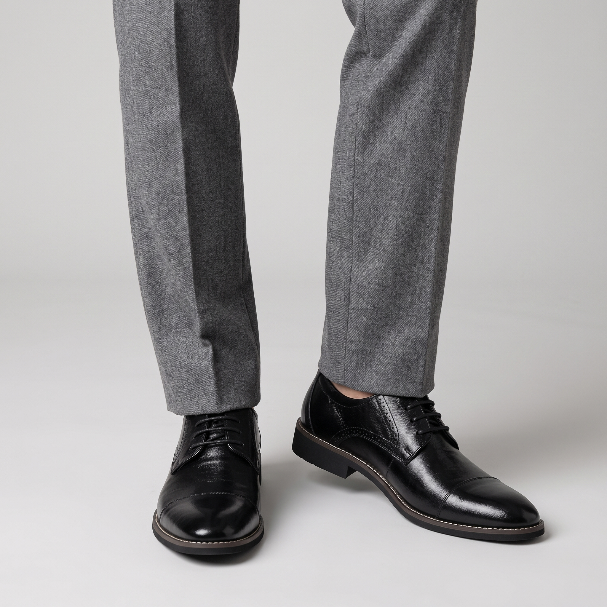 Men's black cap toe Derby shoes with welted sole worn with grey wool trousers