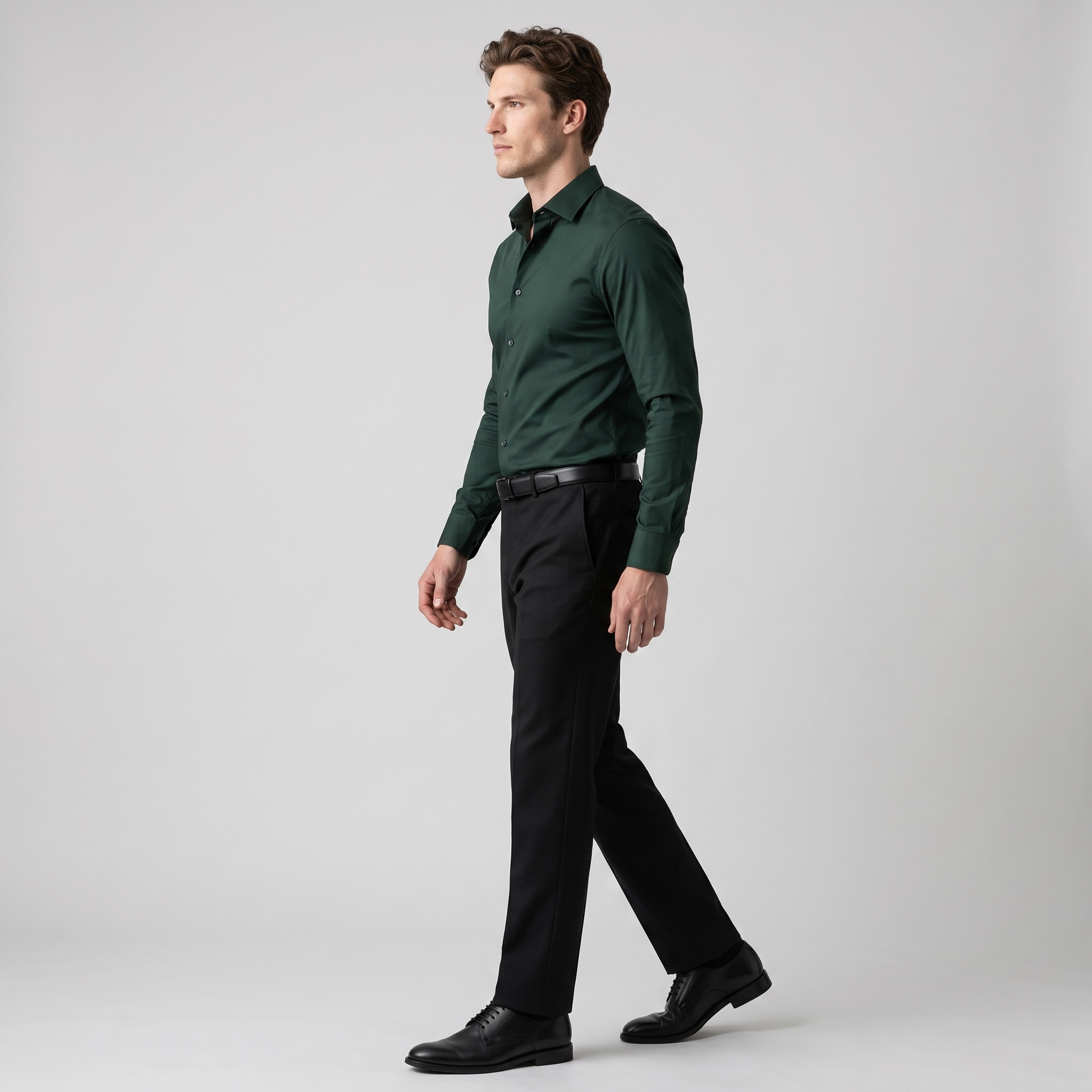 Side view of a dark green slim fit stretch shirt tucked into black trousers