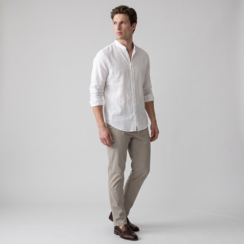 Side view of a white crinkle cotton band collar shirt worn loose over chinos