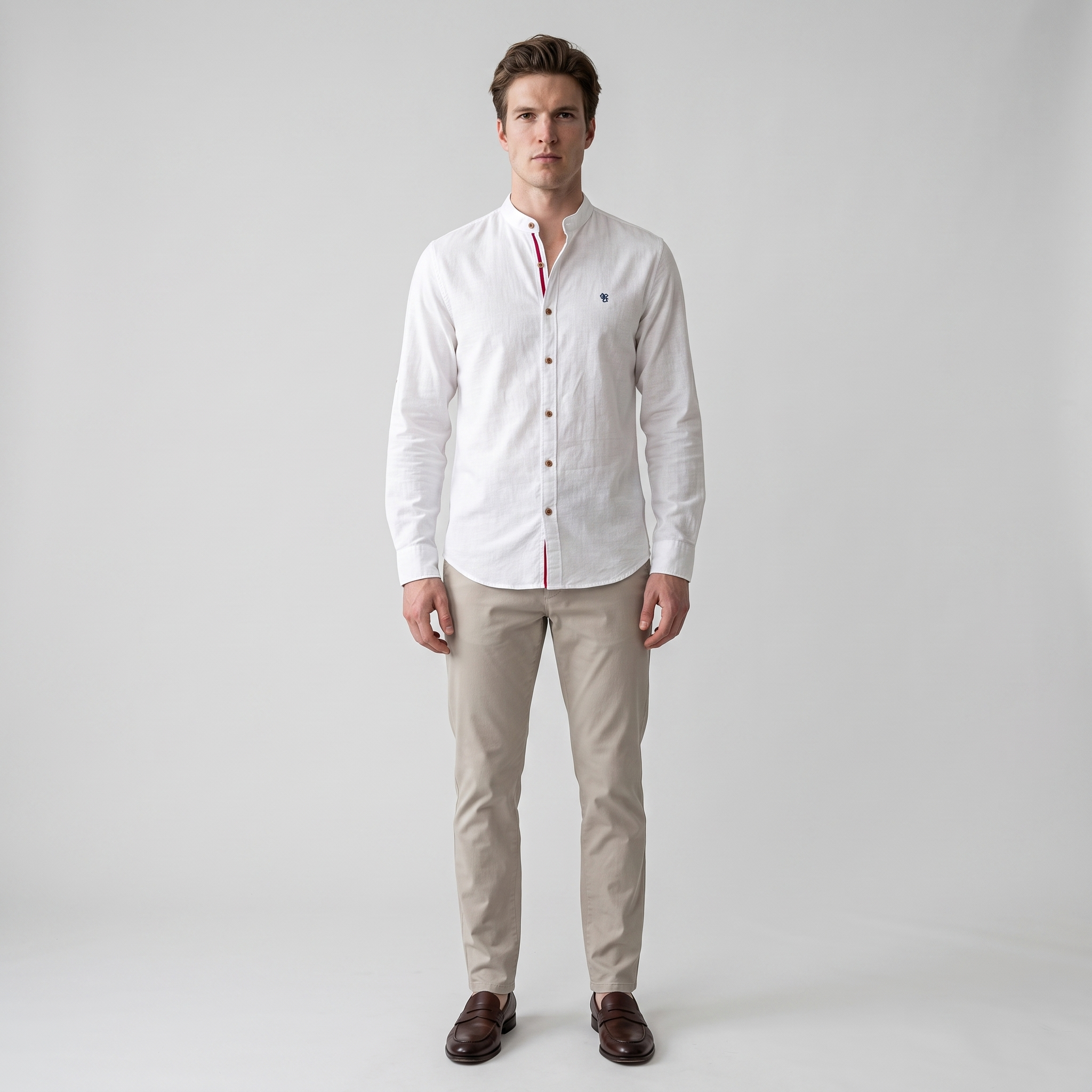 Man wearing a white cotton linen stand collar shirt with embroidered chest motif