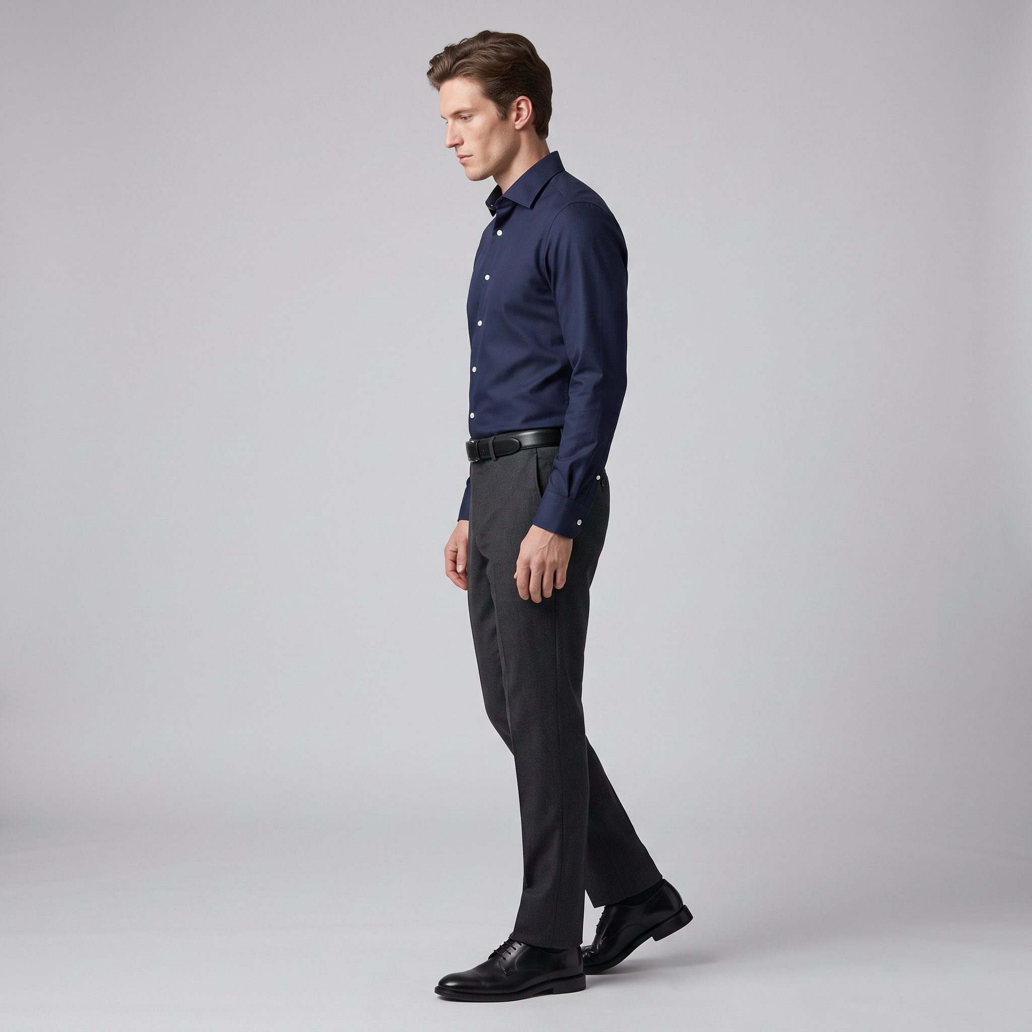 Side view of a navy slim fit twill shirt tucked into charcoal trousers