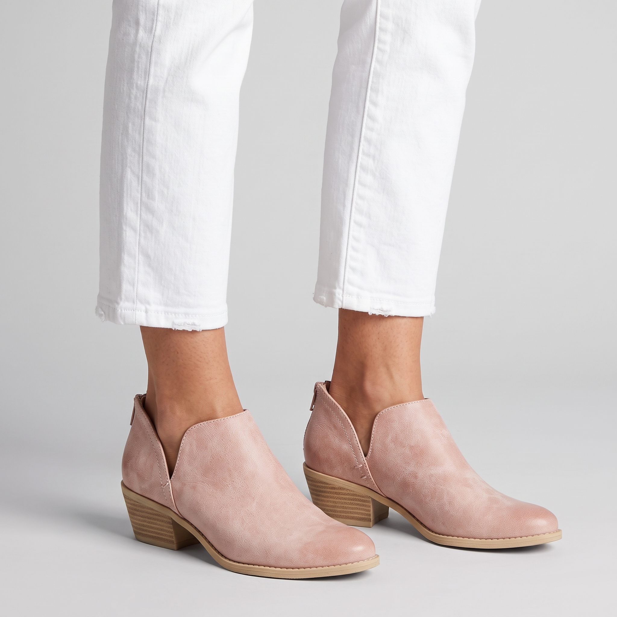 Women's pale pink cut out ankle boots with a low stacked heel and back zip