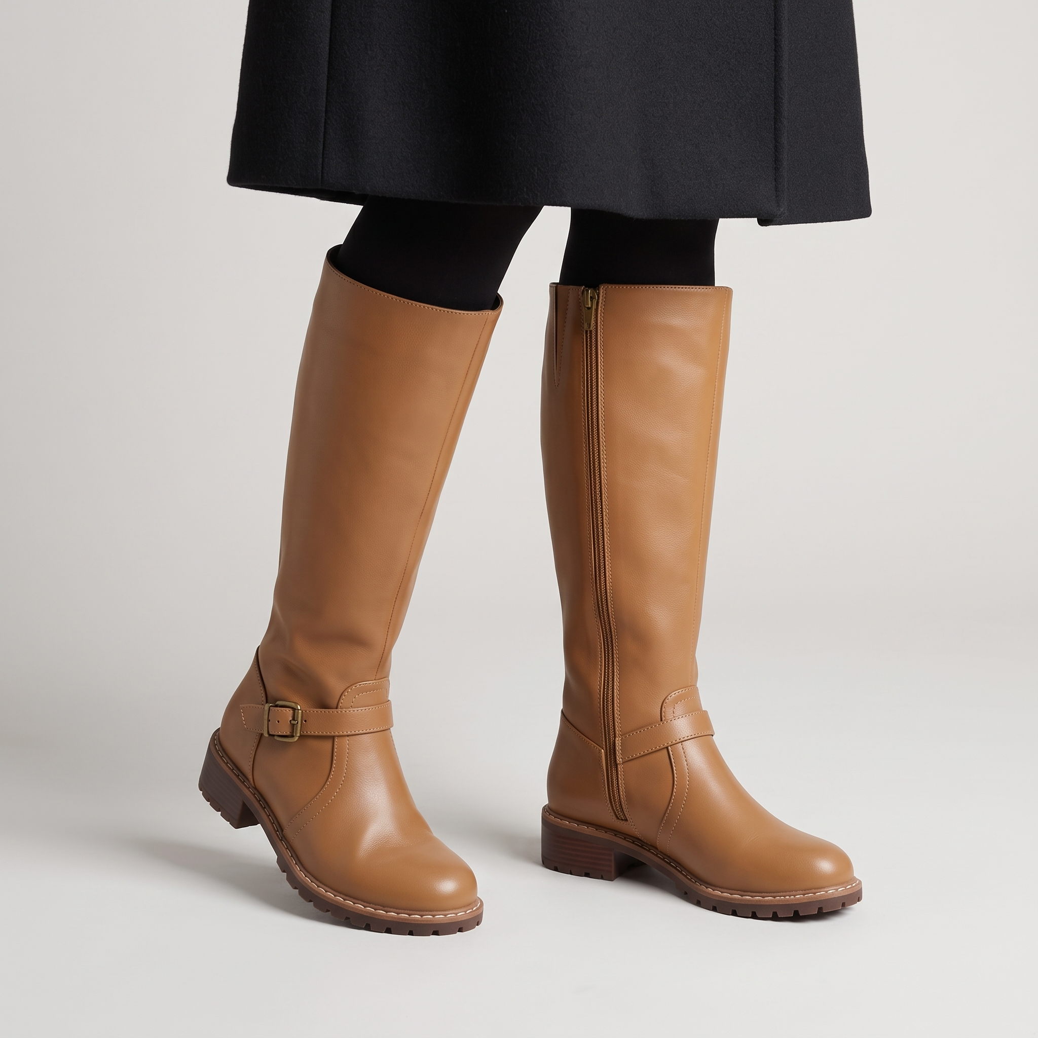 Women's tan knee high riding boots with an antique brass ankle buckle strap