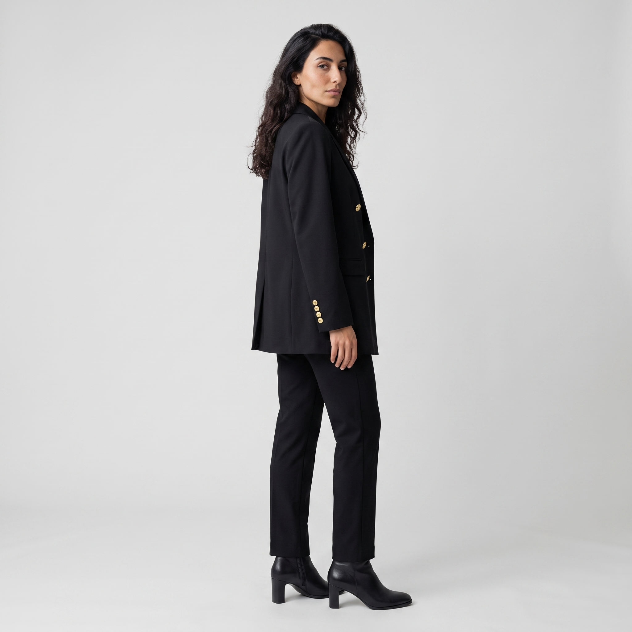 Side view of a black longline blazer showing the three gold cuff buttons