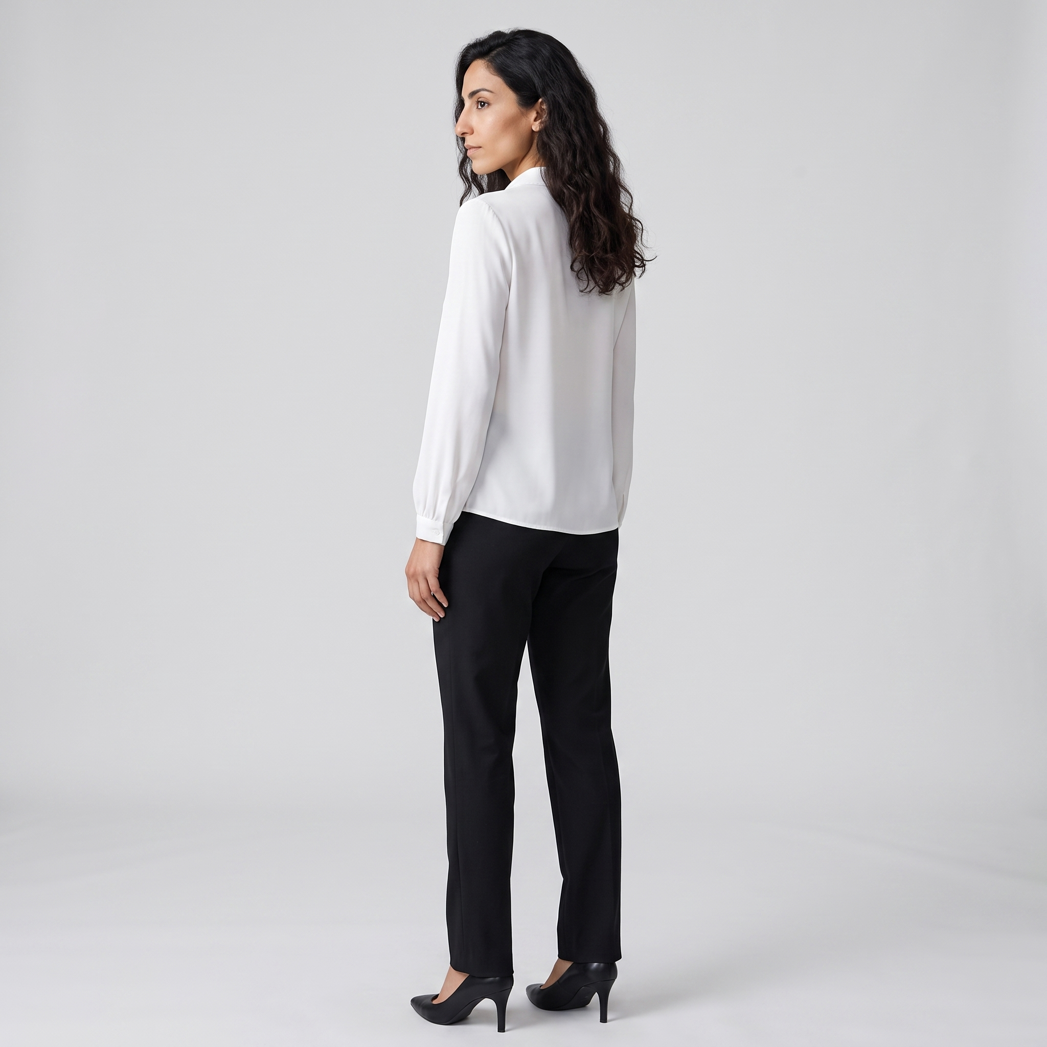 Side view of a white blouse with a concealed placket and black trousers