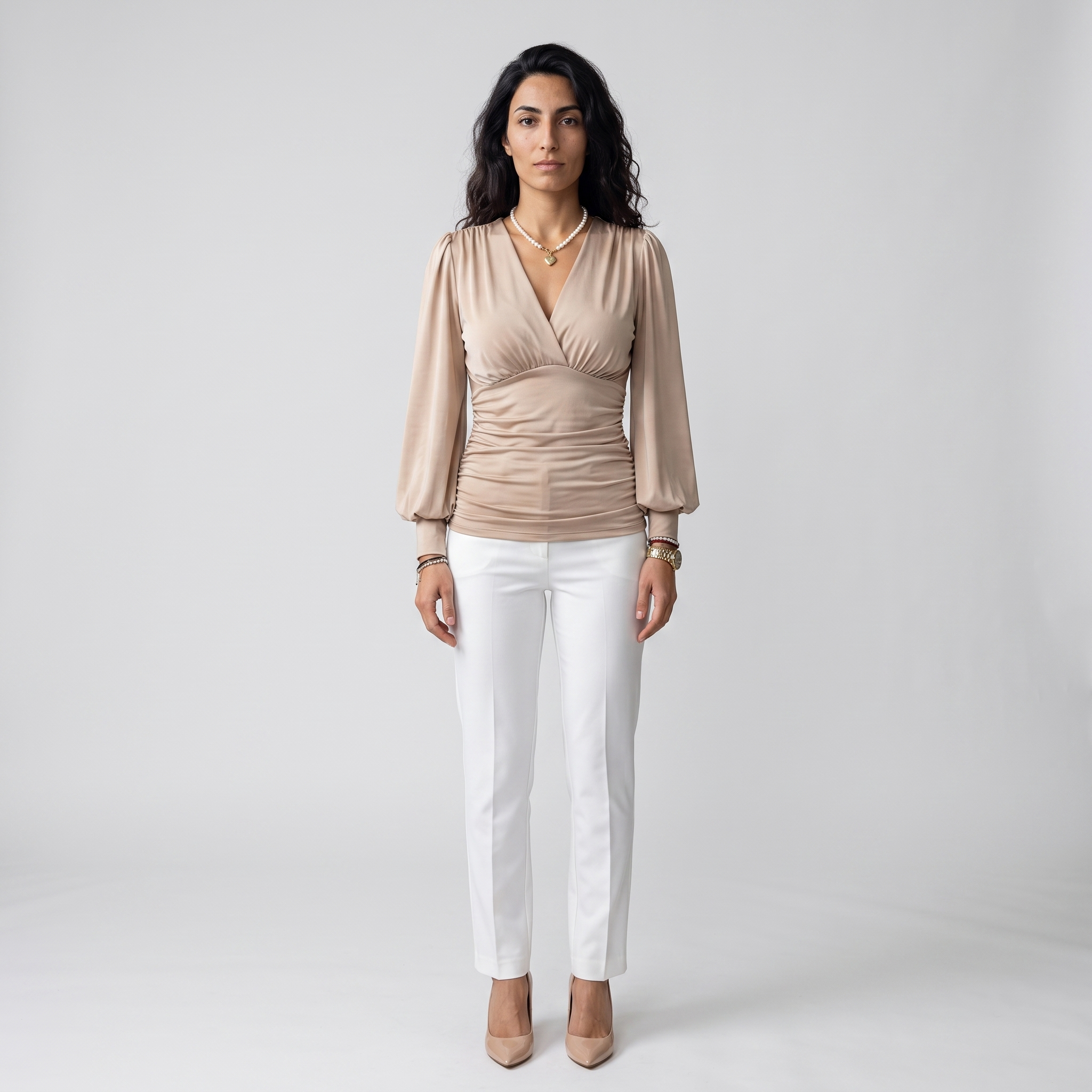 Woman wearing a beige wrap V-neck blouse with a ruched waist and lantern sleeves