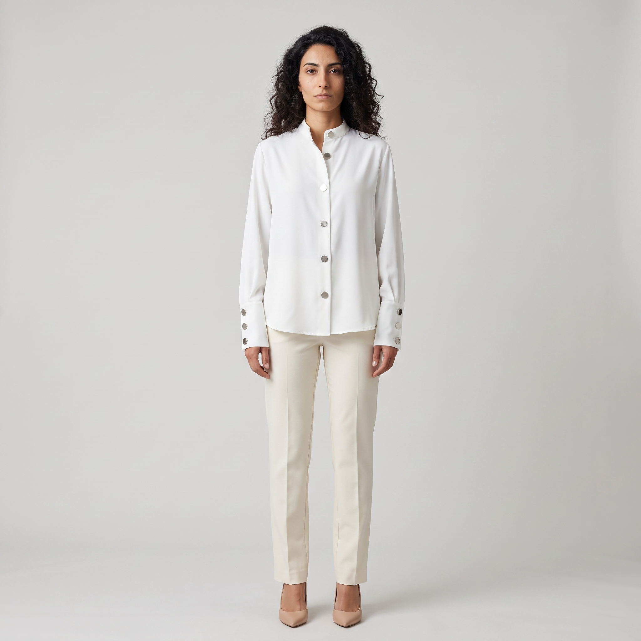 Woman wearing a white stand collar blouse with oversized silver metal buttons