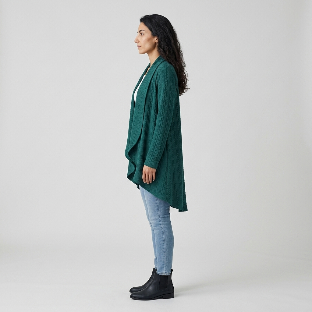 Side profile of teal cable knit cardigan showing asymmetric dipped hem