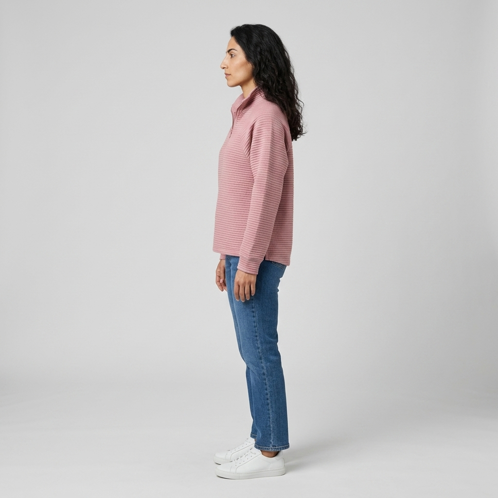 Woman wearing a pink ribbed half zip pullover, side view