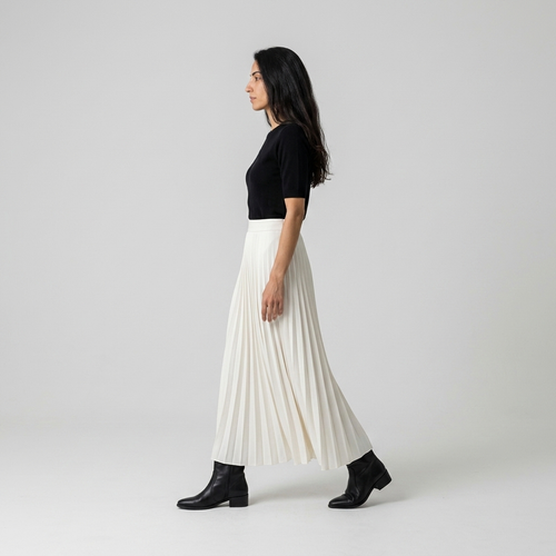 Side view of ivory pleated maxi skirt showing the knife pleats