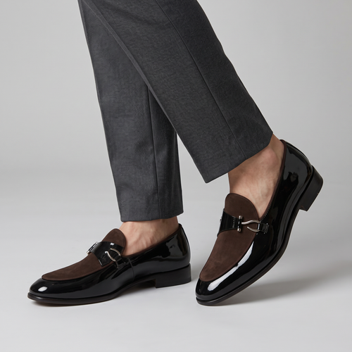 Model wearing the black patent bit loafers with brown suede vamp, studio shot