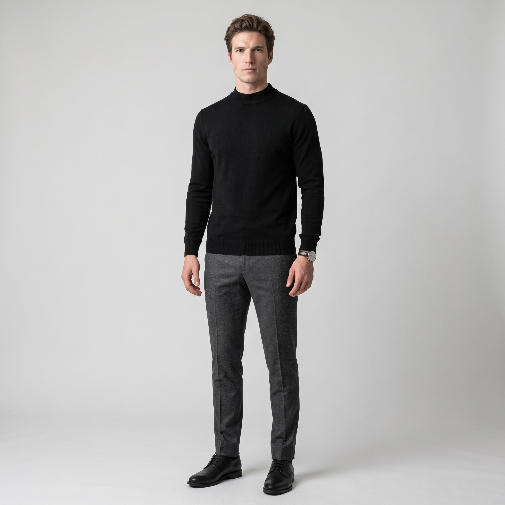 Model wearing the black mock neck knit jumper with charcoal trousers, studio shot