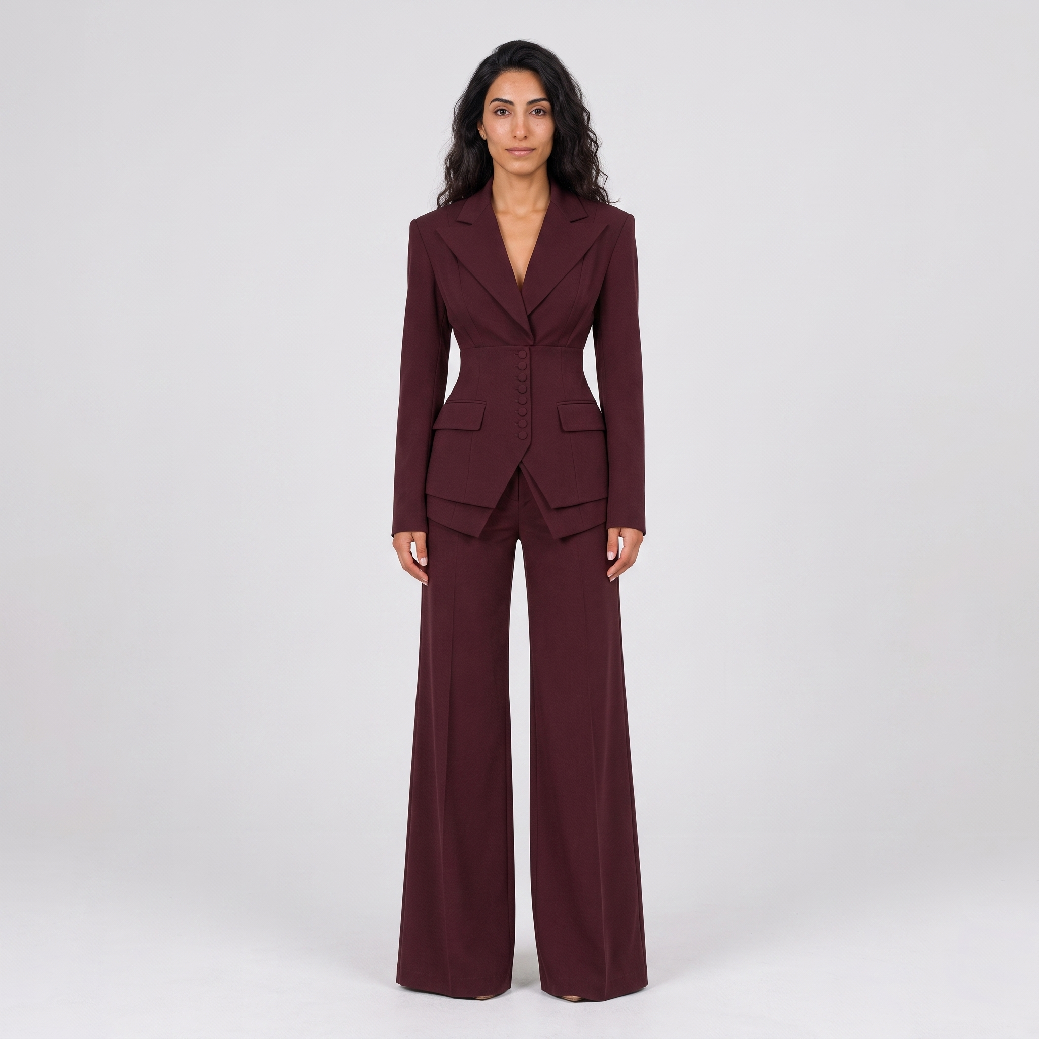 Model wearing the burgundy tailored blazer and wide leg trousers suit, studio shot