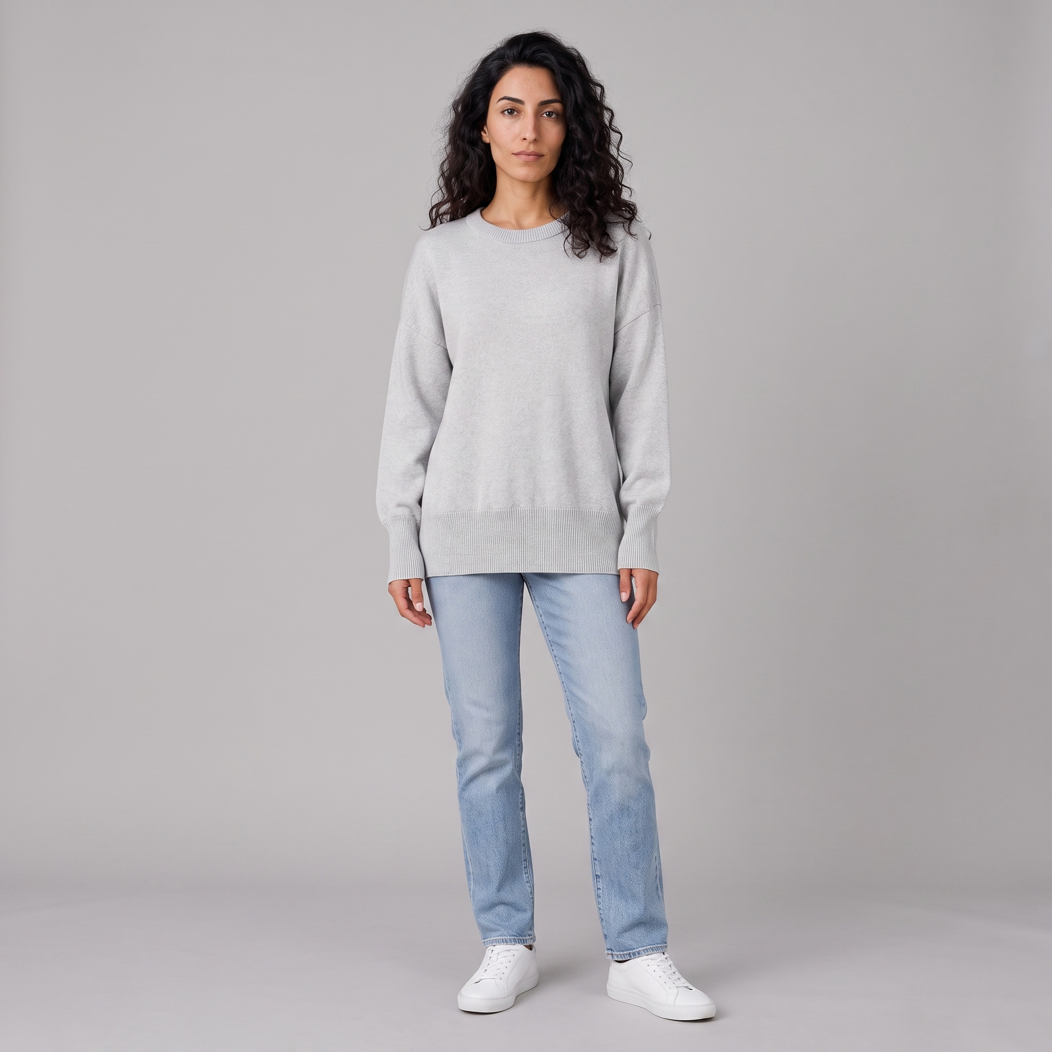 Model wearing the grey oversized knitted crew neck jumper, studio shot
