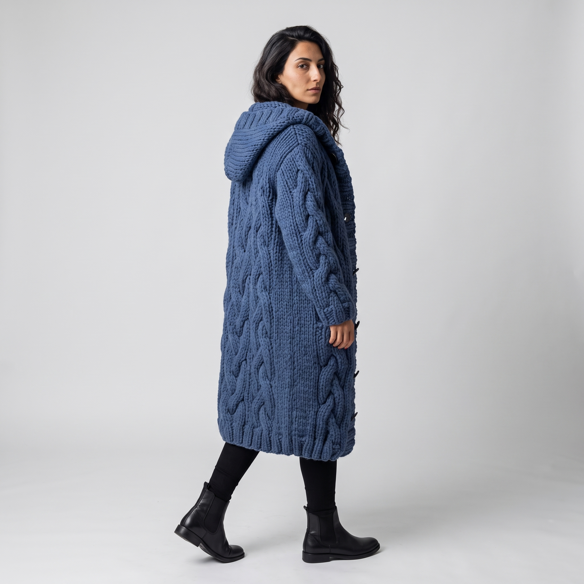 Side view of the blue hooded cable knit cardigan showing the hood and knit depth