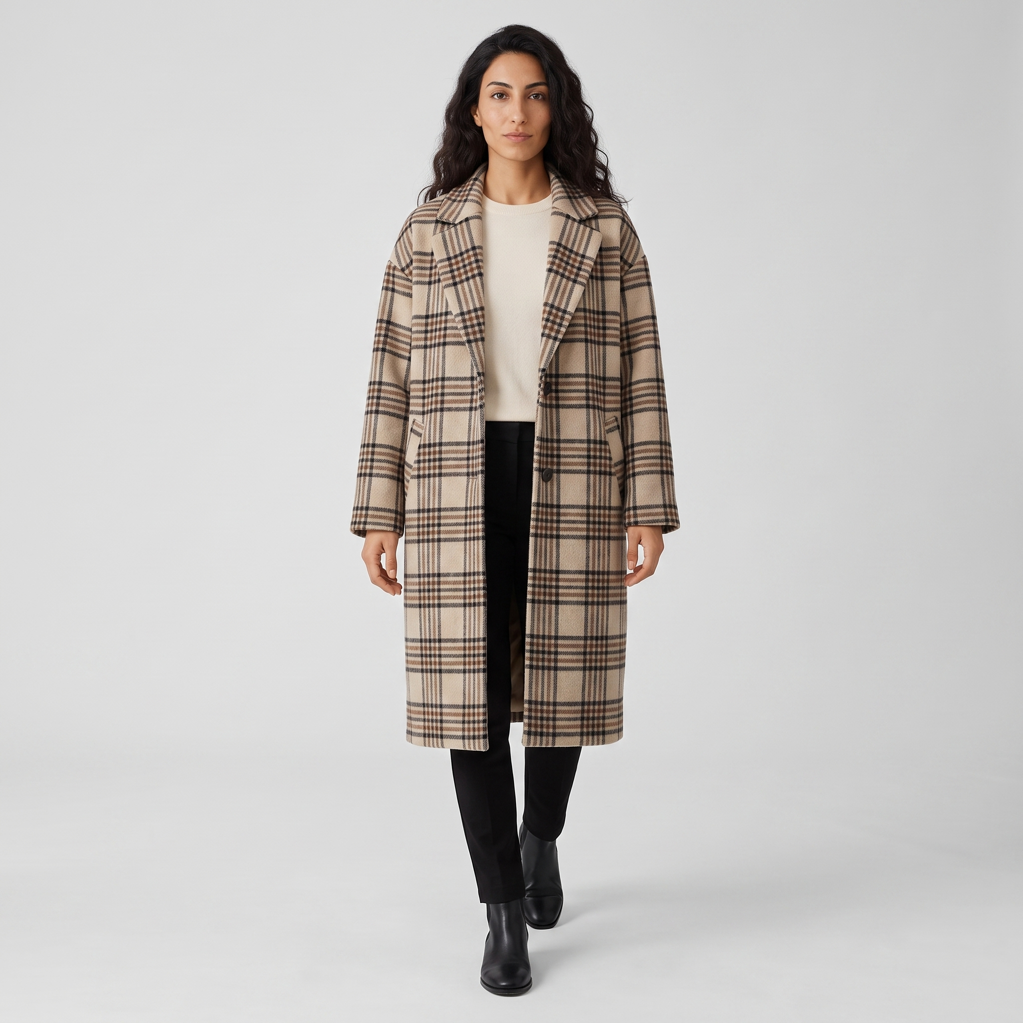 Model wearing the oversized check longline coat open over cream knitwear, studio shot