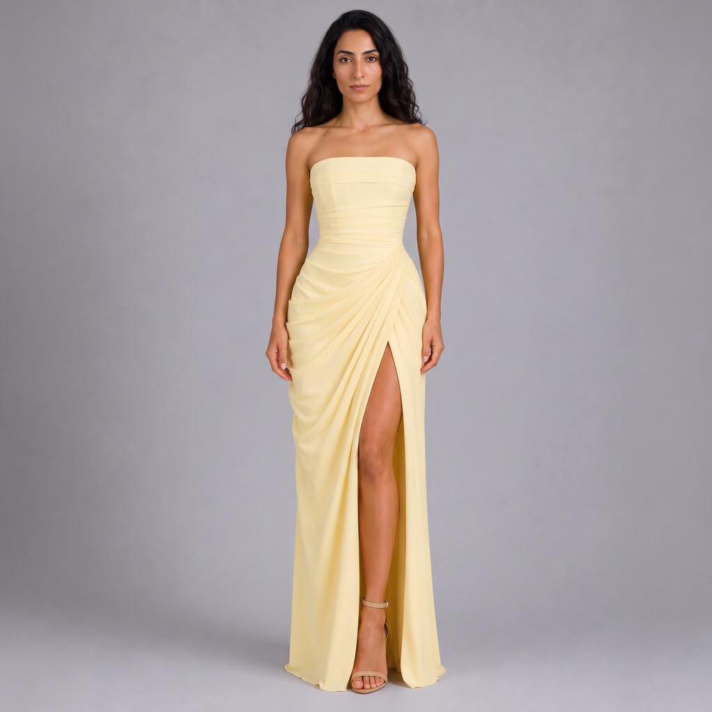 Model wearing the pale yellow strapless draped maxi dress with high split, studio shot